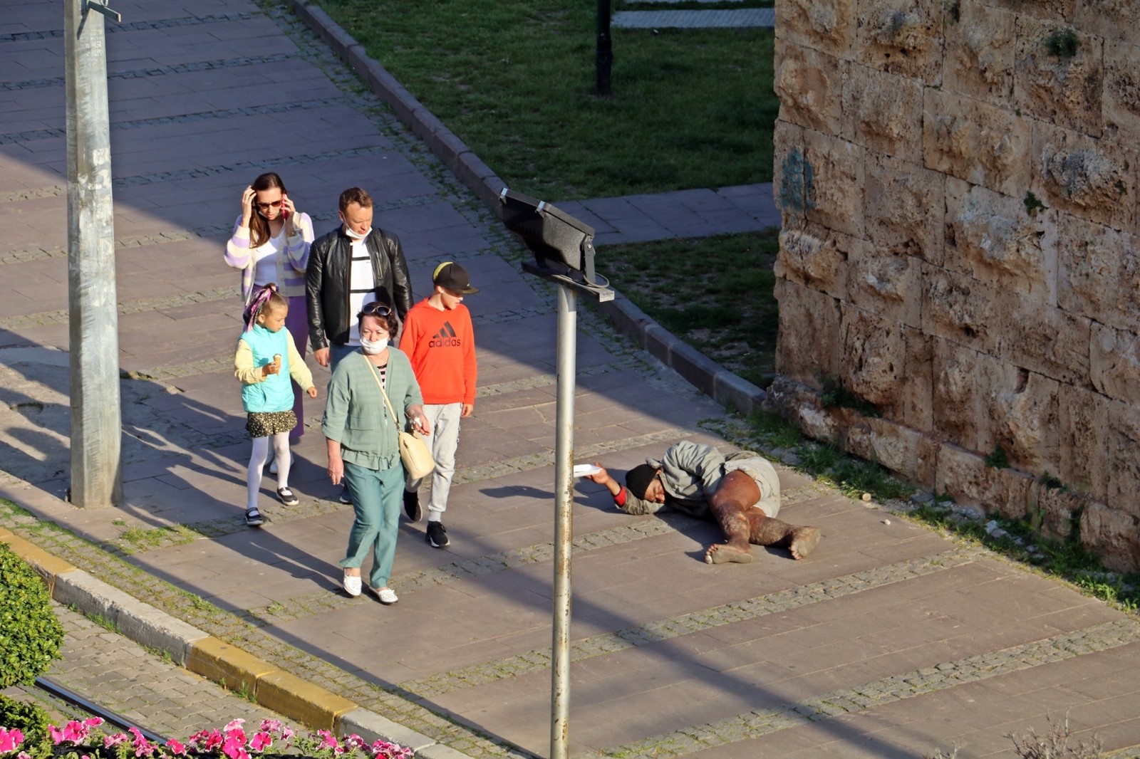 Kaleiçi girişinde kaldırımda yatarak dilendi