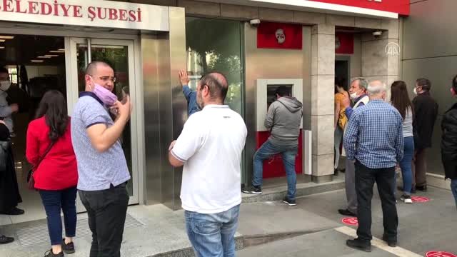 Polis, banka önlerinde sıra bekleyenlere maske dağıttı